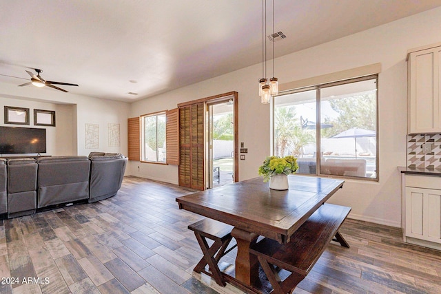 dining space with a ceiling fan, dark wood-style flooring, visible vents, and baseboards