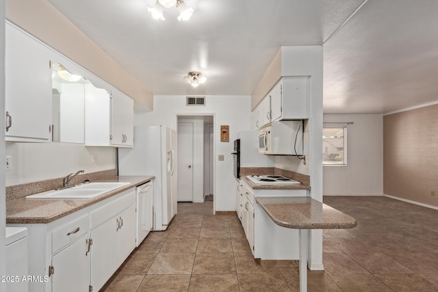 kitchen featuring white appliances, light tile patterned floors, white cabinets, visible vents, and a sink