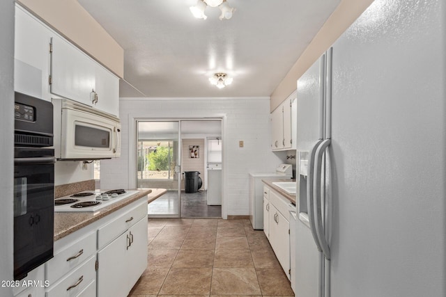 kitchen featuring washer / clothes dryer, light countertops, and white appliances