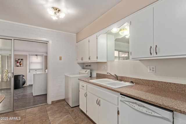 clothes washing area featuring a sink, light tile patterned floors, washer and clothes dryer, and laundry area