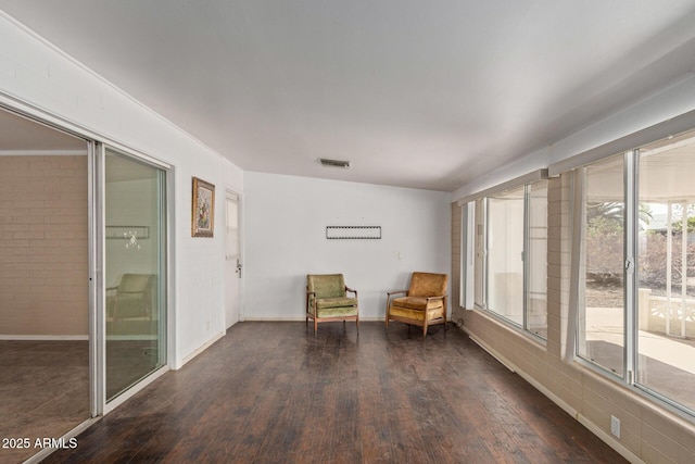 living area with dark wood-style flooring, baseboards, and visible vents