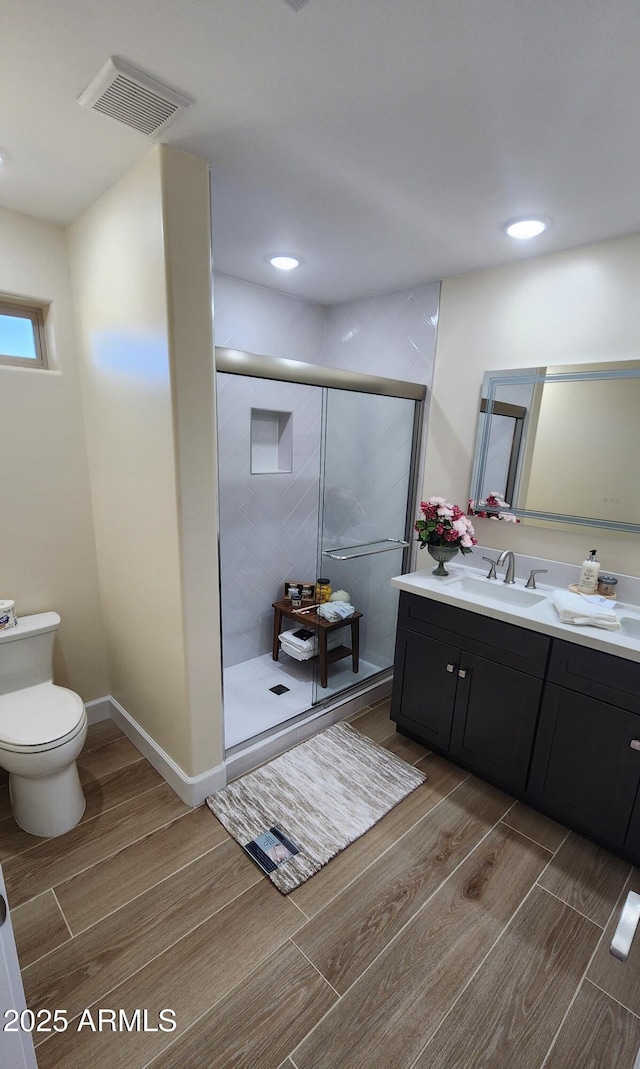 bathroom featuring walk in shower, vanity, and toilet