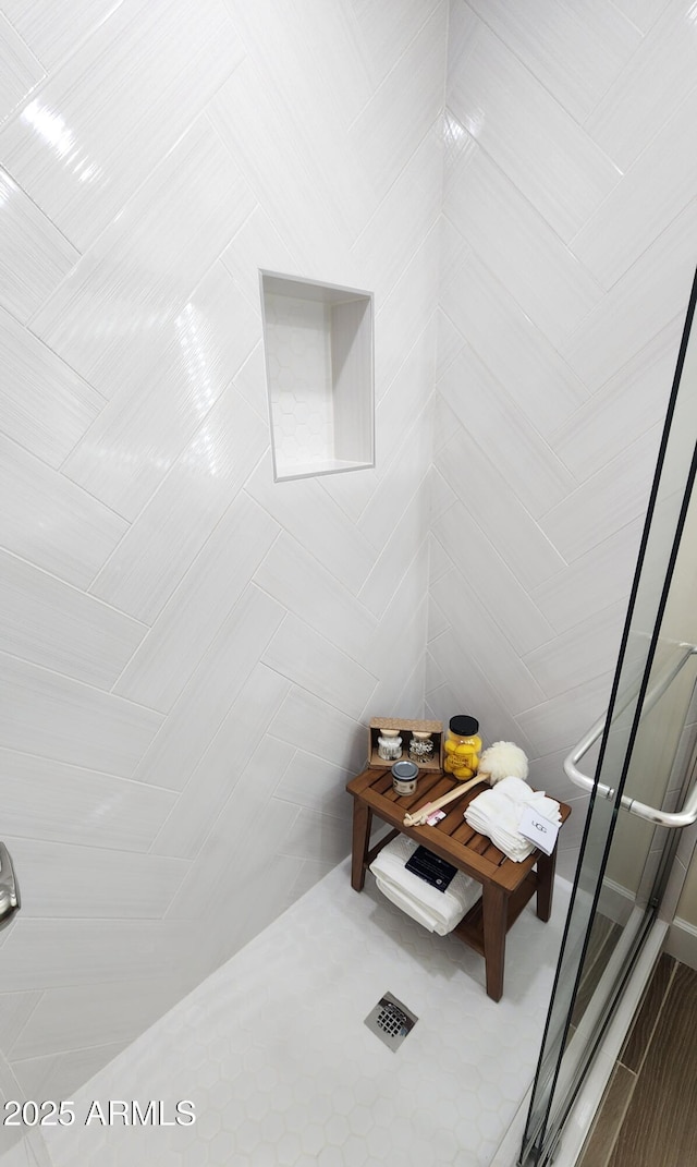 bathroom featuring a shower with door