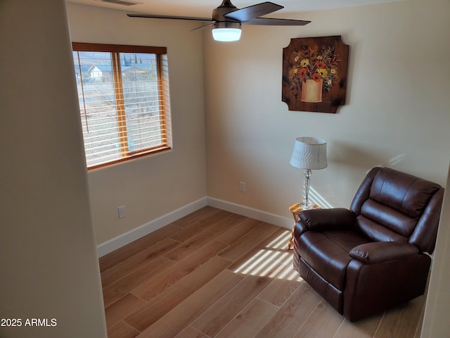 living area with light hardwood / wood-style floors and ceiling fan