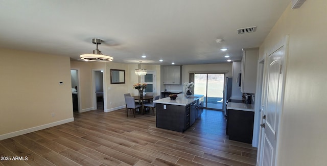 kitchen with sink, a center island, hardwood / wood-style floors, and pendant lighting