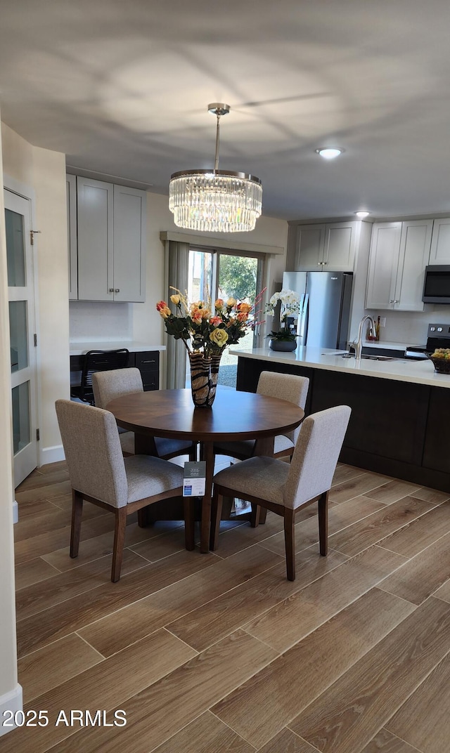 dining room with sink and an inviting chandelier