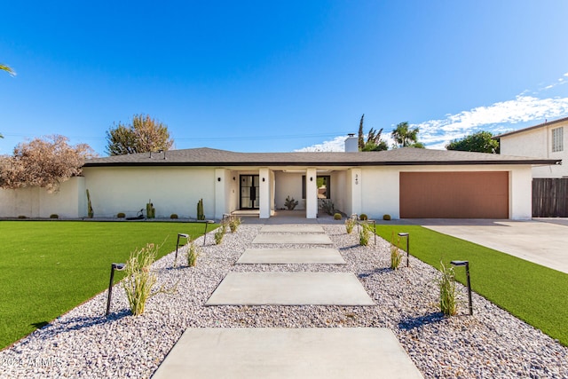 single story home featuring a garage and a front lawn