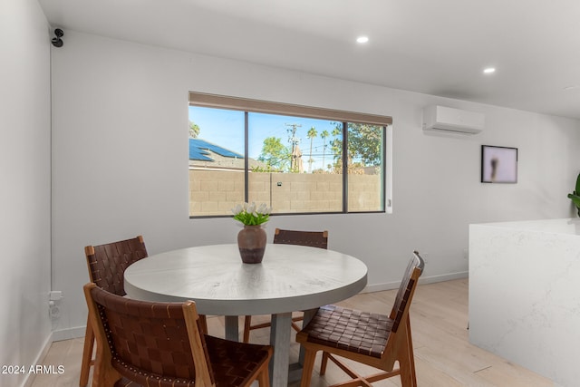 dining area with light wood-type flooring, a wealth of natural light, and a wall mounted air conditioner