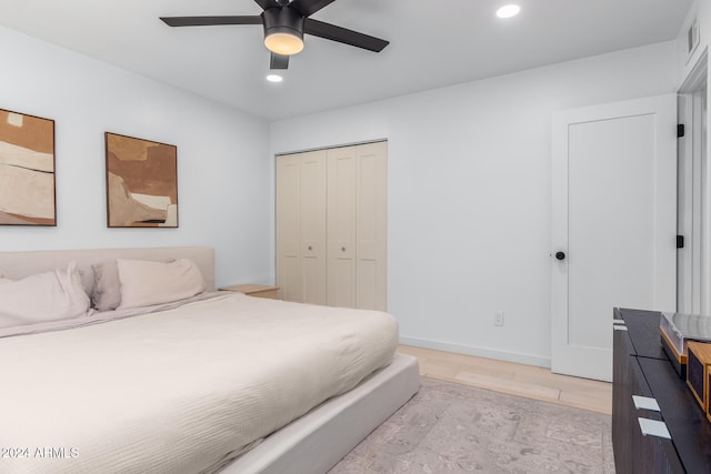 bedroom with a closet, light wood-type flooring, and ceiling fan