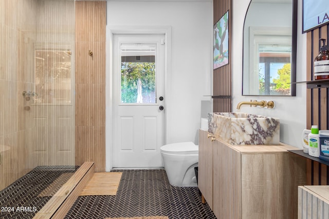 bathroom featuring tiled shower, toilet, and vanity