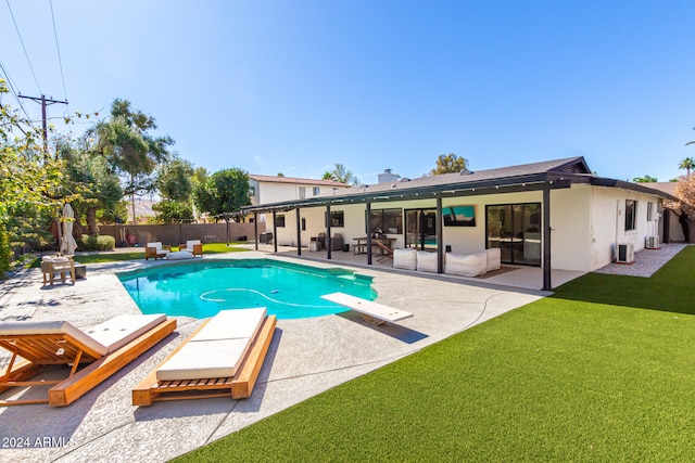 view of swimming pool featuring a patio area, a lawn, and a diving board