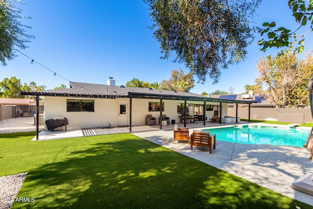 rear view of property featuring a fenced in pool, a patio, and a lawn