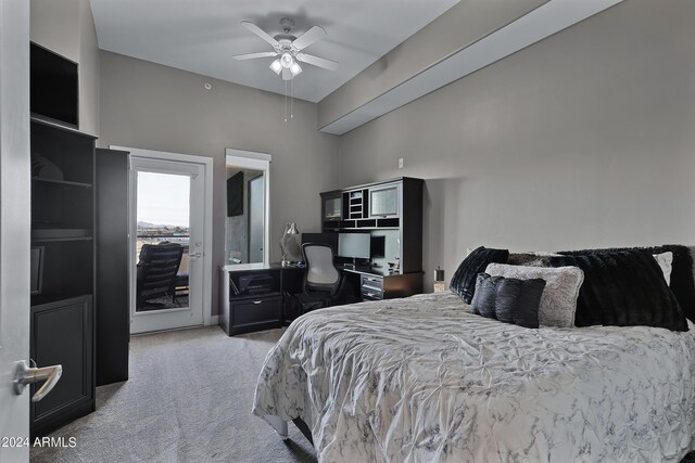 carpeted bedroom with a towering ceiling, ceiling fan, and access to exterior