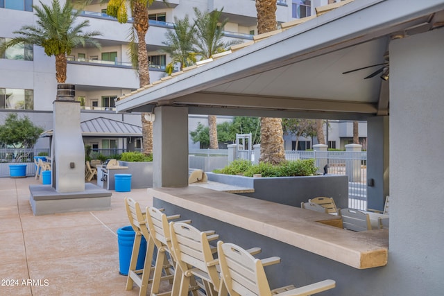 view of patio featuring a balcony, ceiling fan, and exterior bar