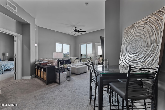 carpeted dining room featuring ceiling fan