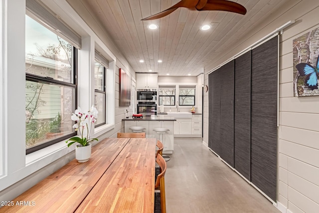 interior space with wood ceiling, ceiling fan, and sink