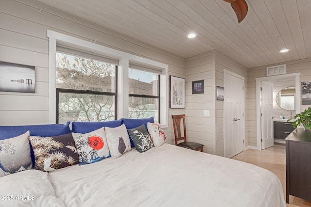 bedroom featuring wood ceiling and wood walls