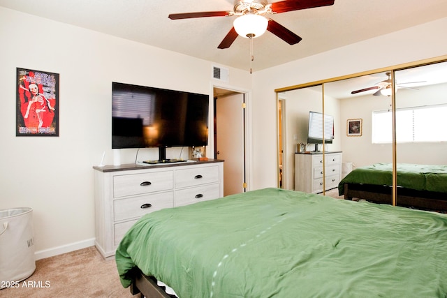 bedroom with visible vents, baseboards, a closet, a ceiling fan, and light carpet