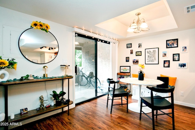 dining room with visible vents, baseboards, an inviting chandelier, dark wood-style floors, and a tray ceiling
