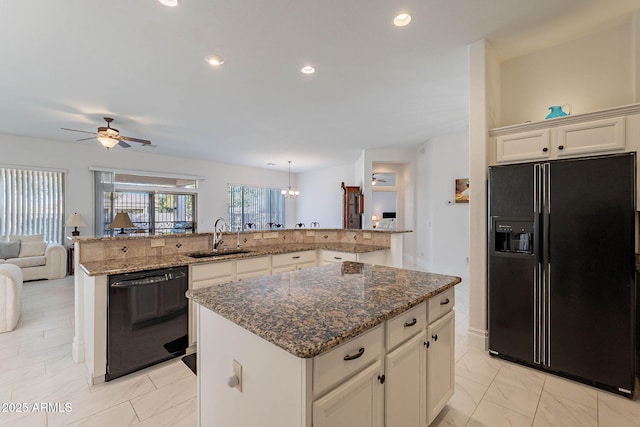 kitchen with sink, a kitchen island, black appliances, stone countertops, and kitchen peninsula