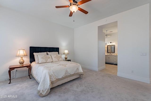 bedroom featuring light carpet, sink, ceiling fan, and ensuite bathroom