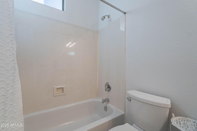 bathroom featuring shower / tub combination and toilet