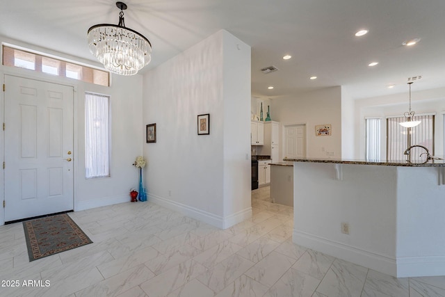 foyer with a healthy amount of sunlight and a chandelier