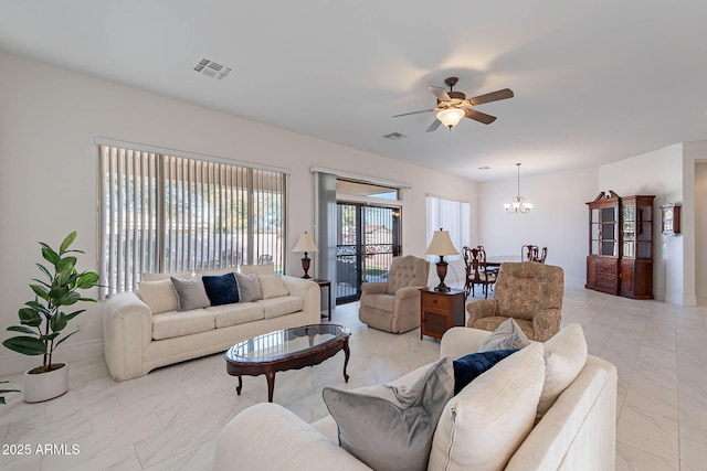 living room with ceiling fan with notable chandelier