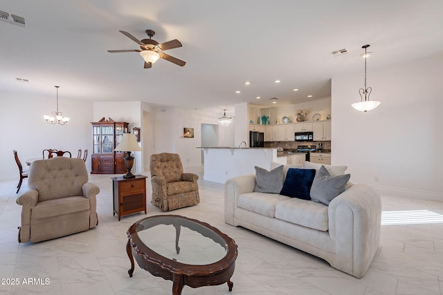 living room featuring ceiling fan with notable chandelier