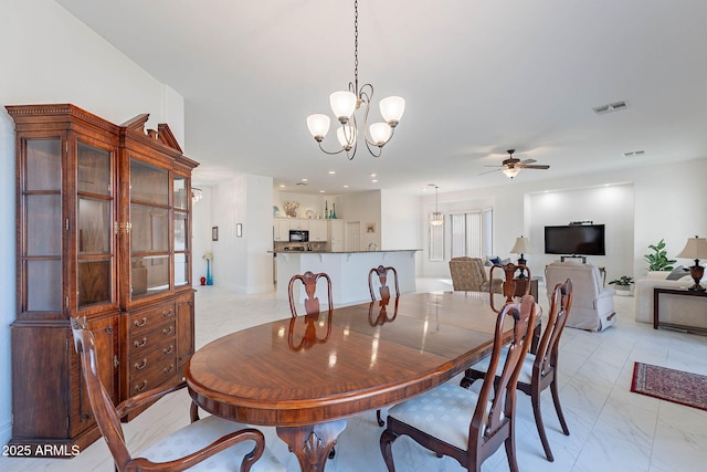 dining space with ceiling fan with notable chandelier