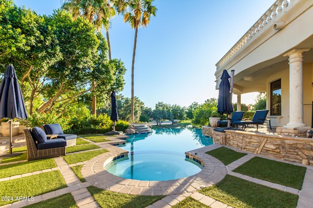 view of pool featuring a jacuzzi and a patio