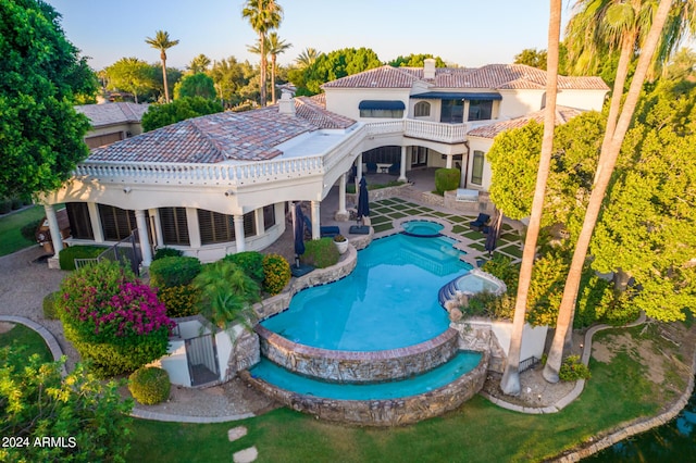 back of property with a patio area and a swimming pool with hot tub