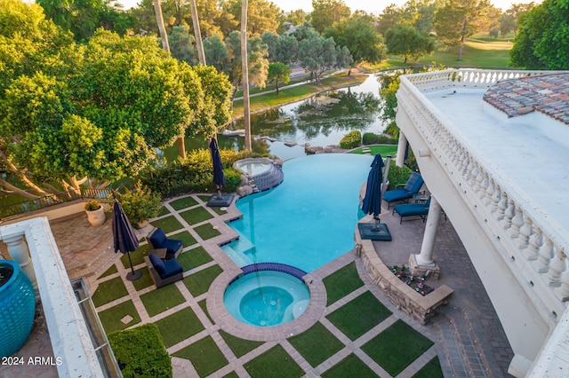 view of swimming pool featuring a water view, an in ground hot tub, and a patio