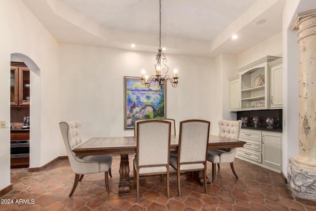 dining area with a raised ceiling and an inviting chandelier