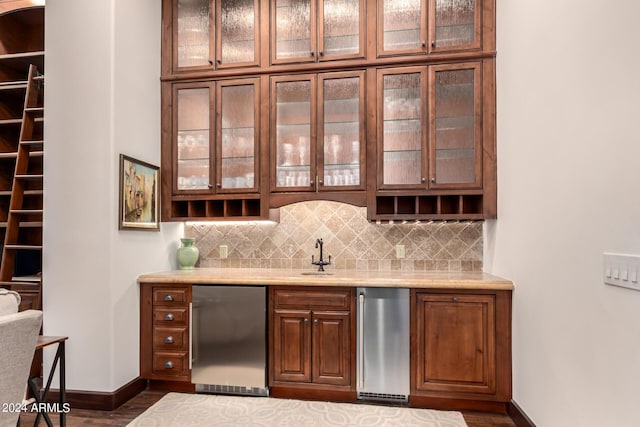 bar with decorative backsplash, refrigerator, dark hardwood / wood-style flooring, and sink