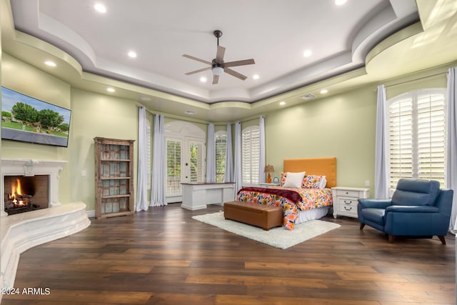 bedroom featuring ceiling fan, dark hardwood / wood-style flooring, and a raised ceiling