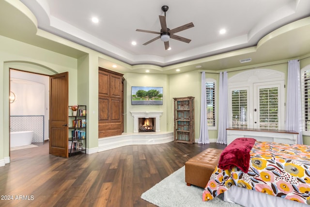 bedroom featuring a tray ceiling, ceiling fan, and dark wood-type flooring