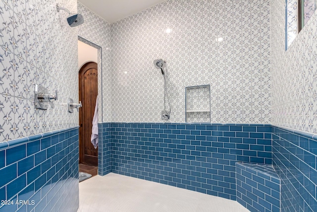 bathroom featuring walk in shower and tile walls