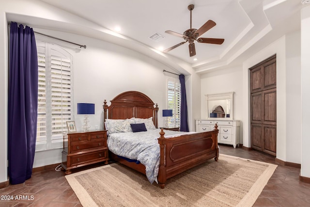 bedroom featuring a raised ceiling and ceiling fan