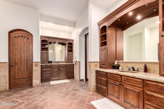 bathroom featuring vanity and tile walls