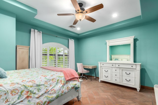 bedroom with a raised ceiling and ceiling fan