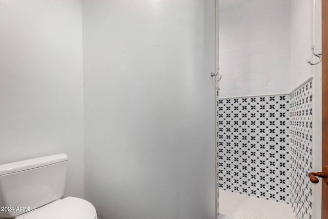 bathroom with toilet and tiled shower