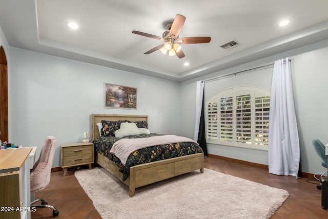 bedroom featuring a tray ceiling and ceiling fan