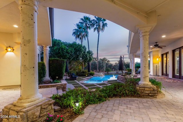 patio terrace at dusk featuring ceiling fan