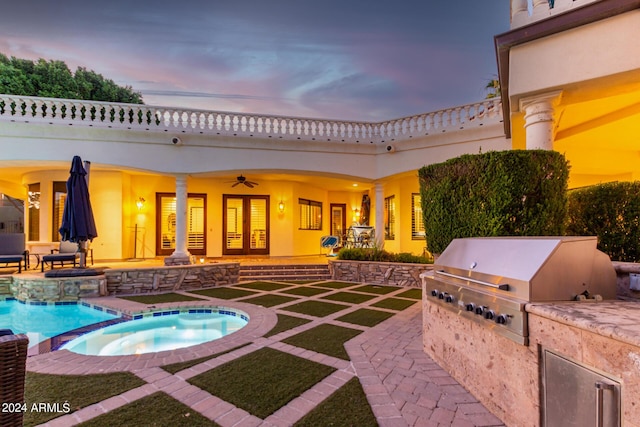 pool at dusk featuring area for grilling, an in ground hot tub, and a patio