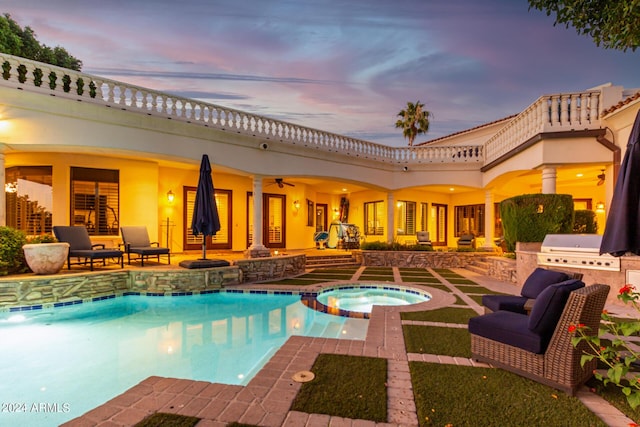 pool at dusk with an in ground hot tub, a patio, area for grilling, and grilling area