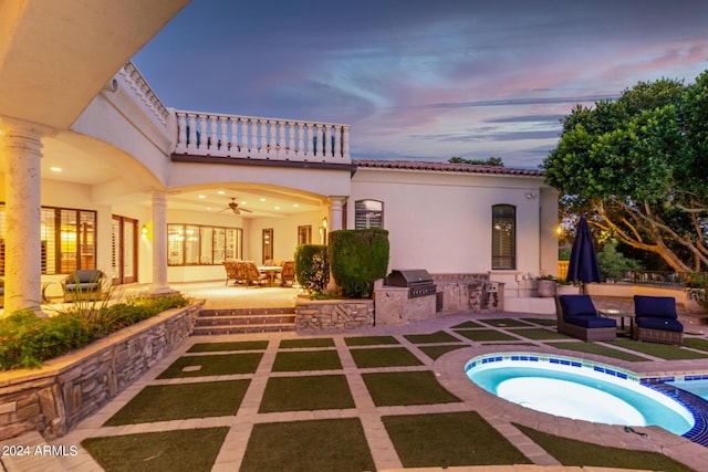 back house at dusk with an in ground hot tub, an outdoor hangout area, area for grilling, ceiling fan, and a patio area