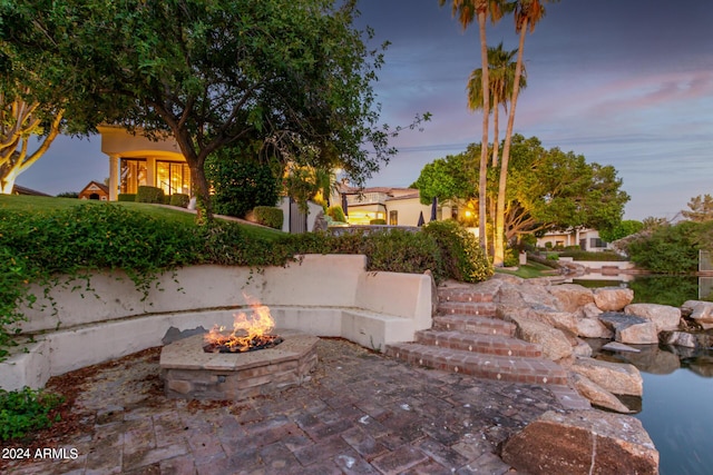 patio terrace at dusk featuring a fire pit