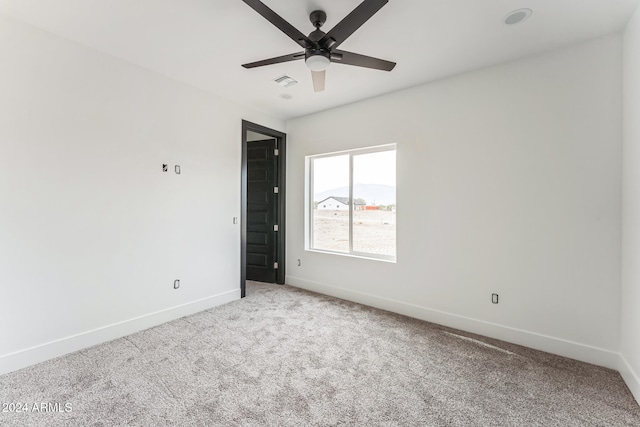 carpeted spare room featuring ceiling fan