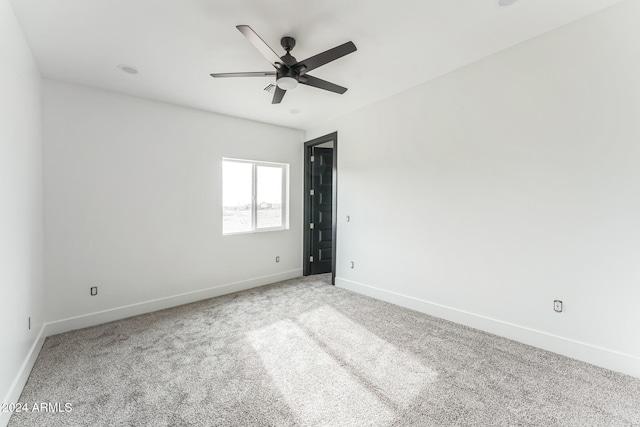 spare room featuring light carpet and ceiling fan